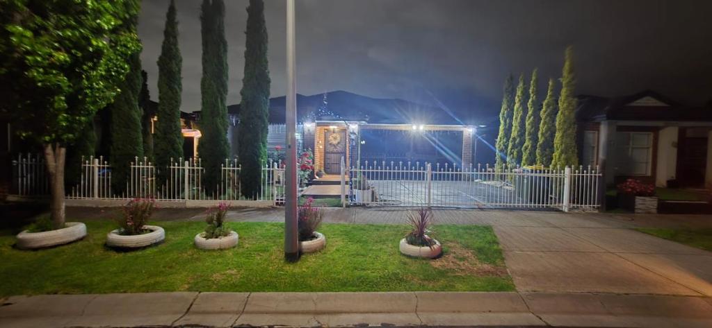 a yard with potted plants and a fence at night at HolidaysHouse Close to Melbourne in Truganina