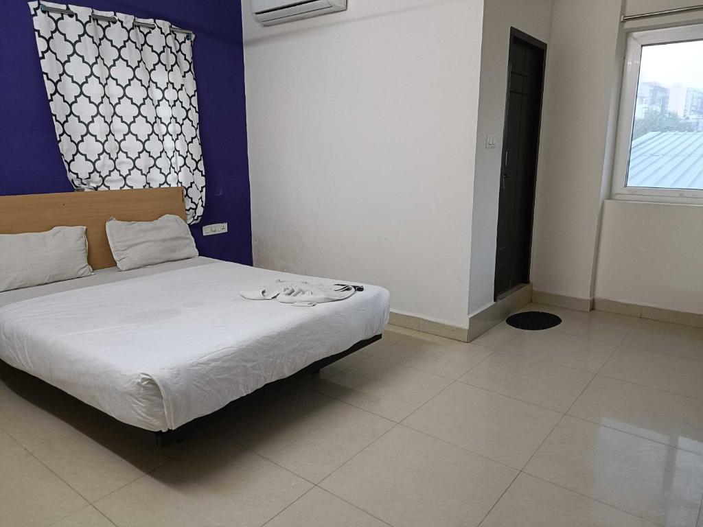 una camera da letto con un letto con lenzuola bianche e una finestra di HOTEL O A QUBE a Bībīnagar