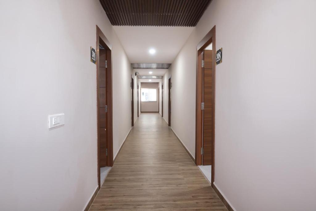 a corridor of an empty room with wooden floors and doors at Hotel Qualia Oak in Hyderabad