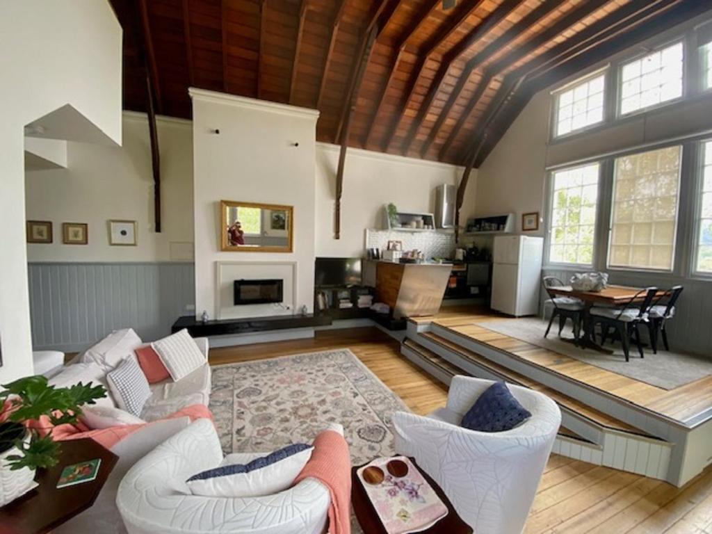 un soggiorno con mobili bianchi e soffitto in legno di Convent Franklin - Schoolhouse Apartment a Franklin