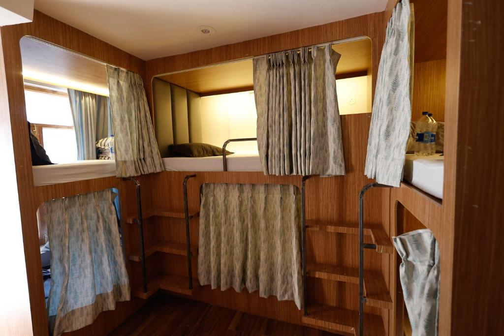 een kleine kamer met 2 stapelbedden en een spiegel bij Joeys Hostel Manali in Manāli