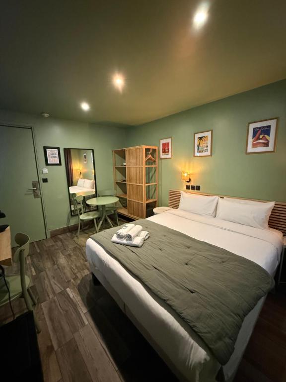 a bedroom with a large bed and a table at Hotel de Berne in Nice