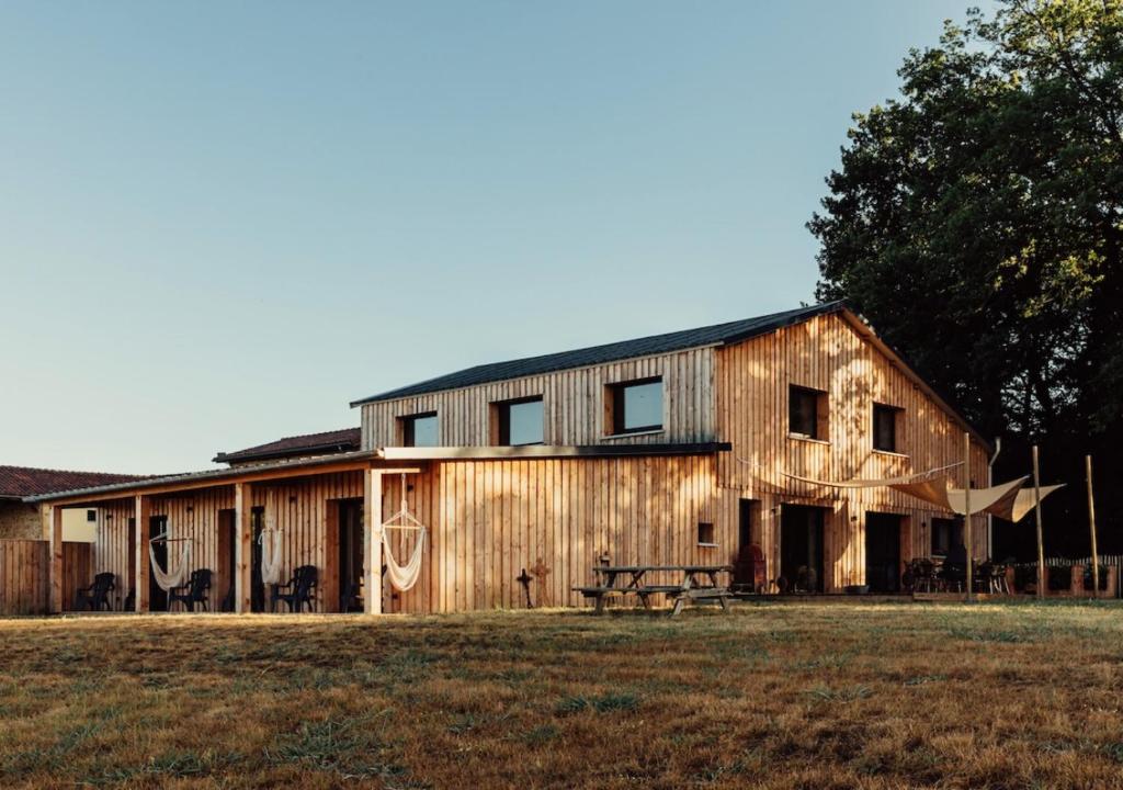 a wooden barn with a picnic table in a field at GiteLaGrange in Lalanne-Arqué