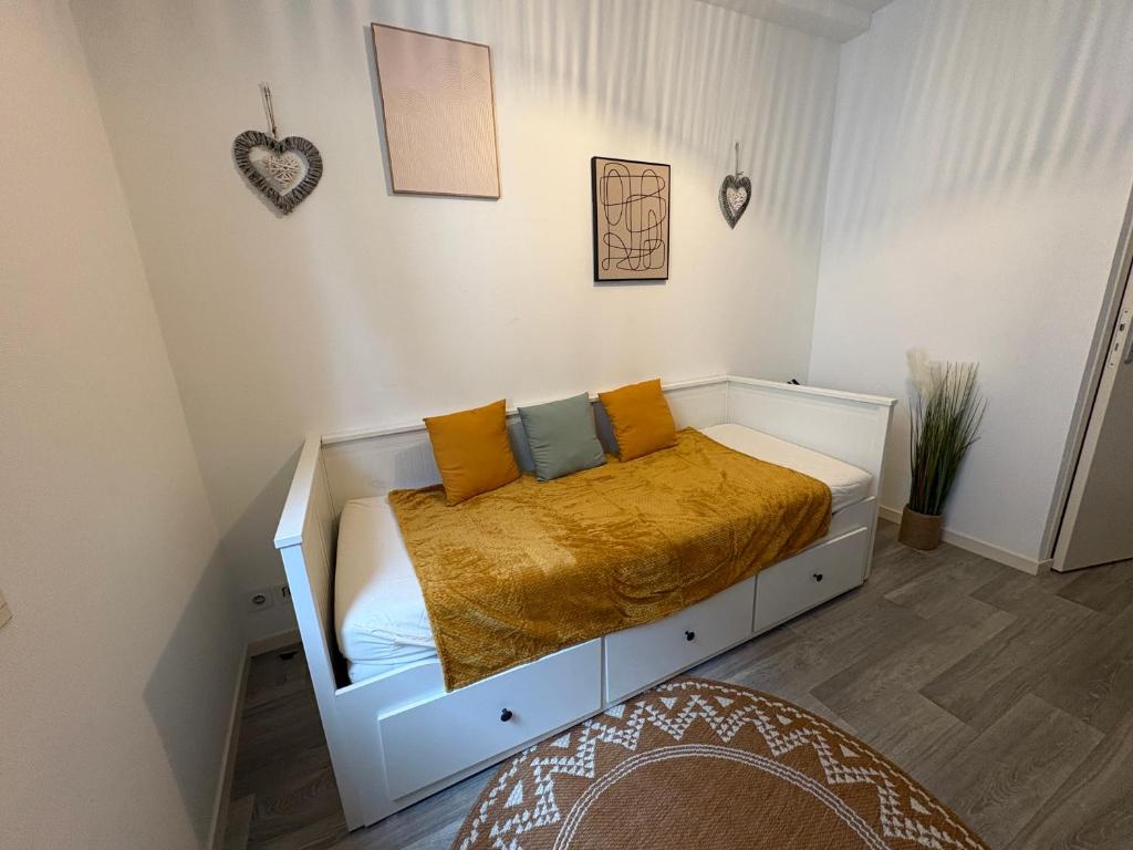 a bedroom with a white bed with yellow sheets at Studio Lumineux Place de Jaude in Clermont-Ferrand