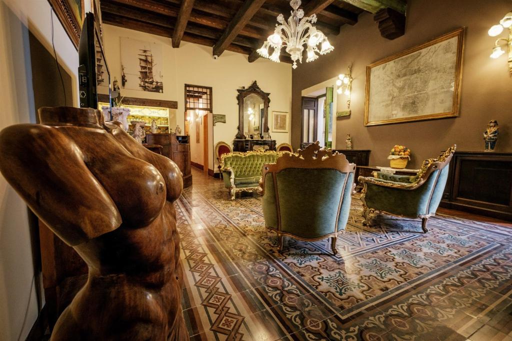 a living room with a statue in the middle of a room at Hotel Henry's House in Syracuse