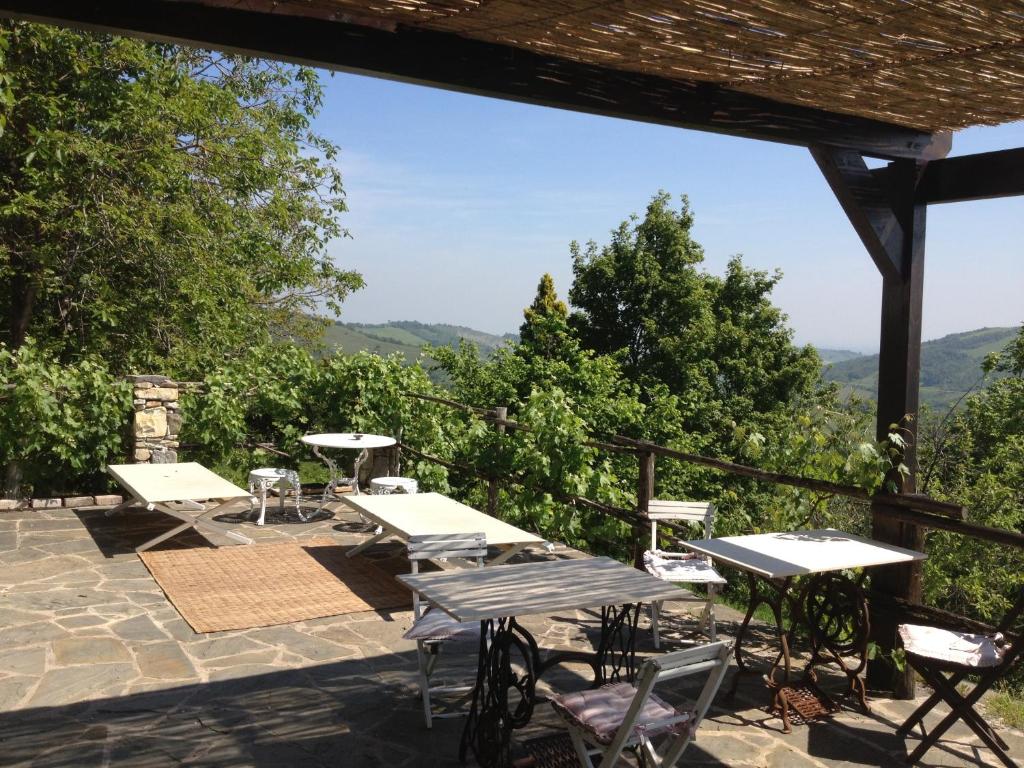 a patio with tables and chairs and mountains in the background at B&B Casa della Musica in Vezzano sul Crostolo