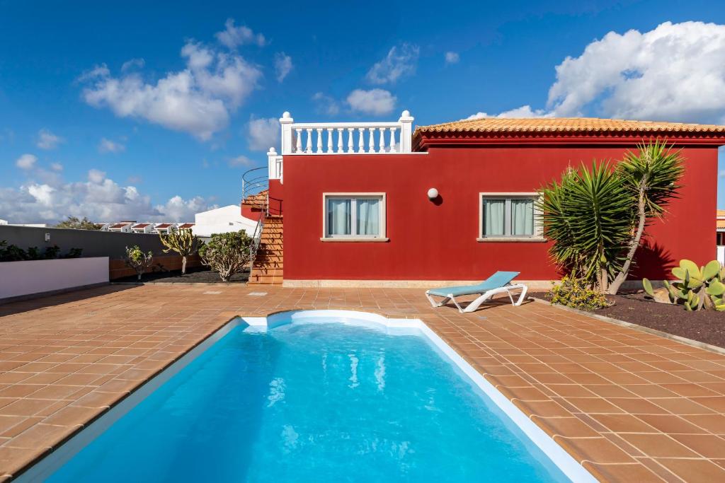 eine Villa mit einem Swimmingpool vor einem Haus in der Unterkunft Villa La Perla - Cliffside Retreat in Antigua
