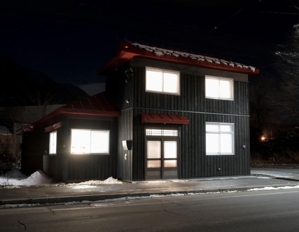 a building with four windows on a street at night at 66 Lodge Country Station in Kimobetsu