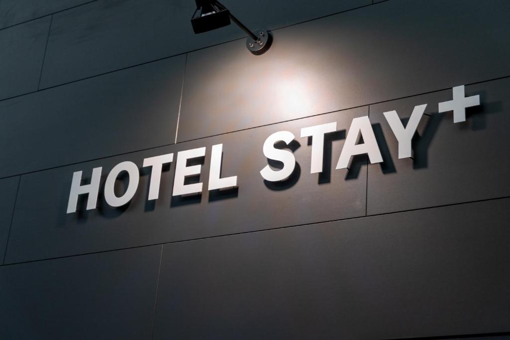 ein Schild mit der Aufschrift „Hotelaufenthalt“ an einer Wand in der Unterkunft HOTEL STAY Plus in Imabari