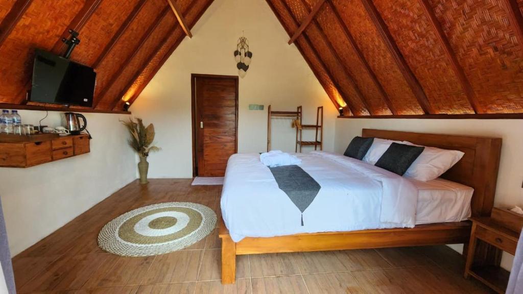 une chambre avec un grand lit et une télévision dans l'établissement Pondok Kanginan, à Plaga