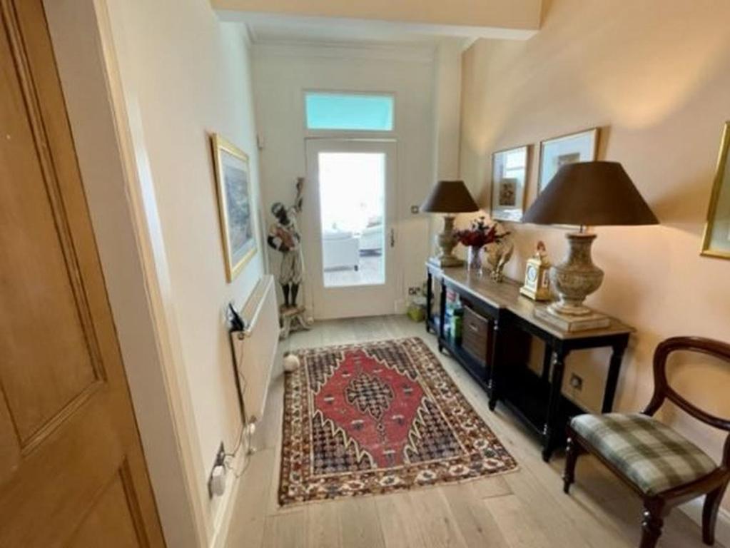 a hallway with a table and a chair and a door at Craigiebank - Lower Largo in Lower Largo