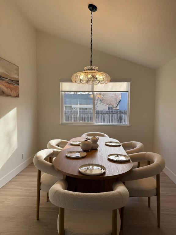 einen Esstisch mit Stühlen und einem Kronleuchter in der Unterkunft New! Modern 4BR max 12 ppl, 5 mins to everything! in Reno