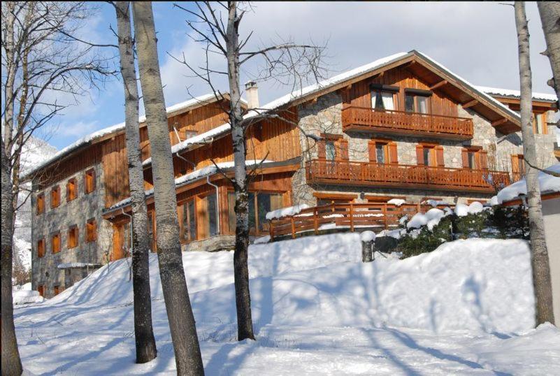 a large wooden house in the snow with trees at Hotel Autantic in Bourg-Saint-Maurice