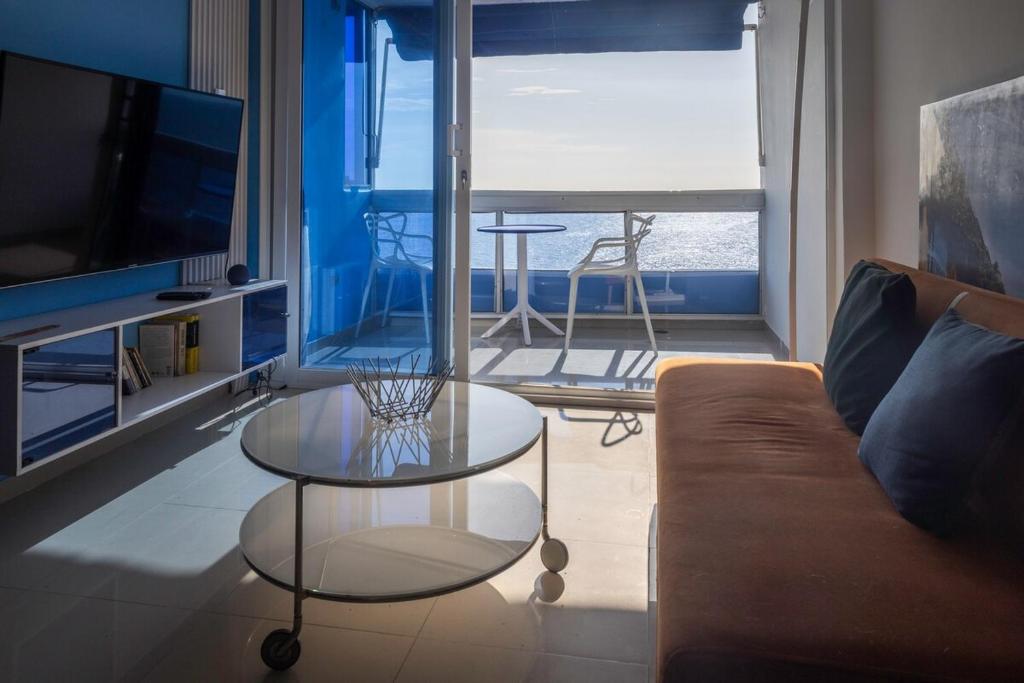 a living room with a couch and a glass table at Balcony to the Horizon in Cartagena de Indias