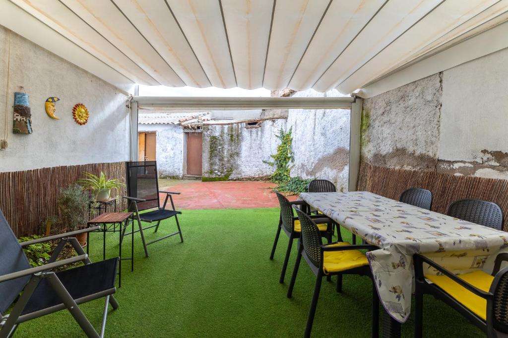 a room with a table and chairs and green grass at Alojamiento cerca de Puy de Fou in Manzaneque
