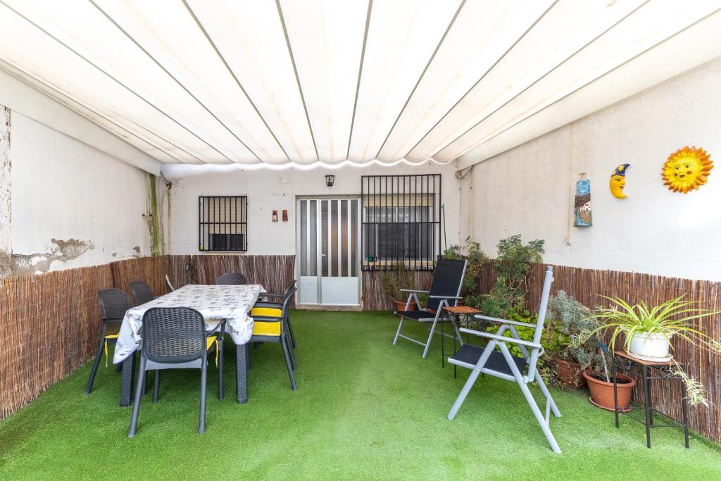 un patio avec une table et des chaises sur l'herbe dans l'établissement Sol y luna, à Manzaneque