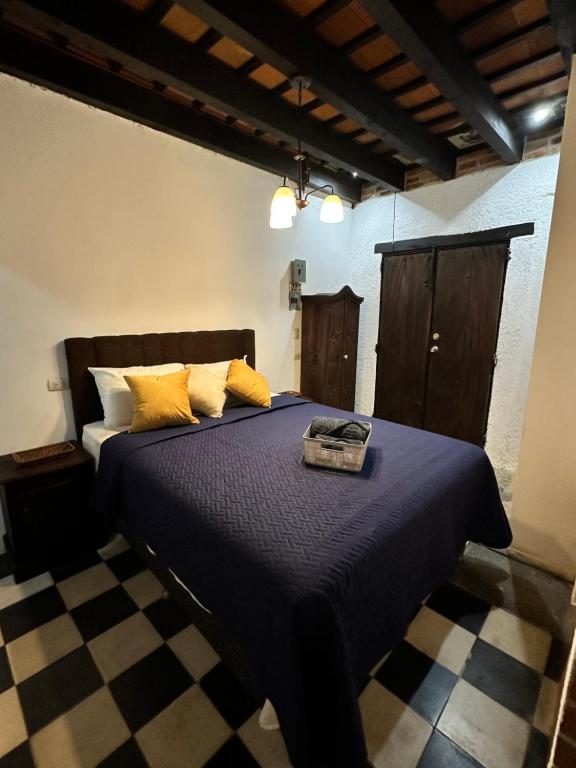 a bedroom with a blue bed with yellow pillows at Refugio de las Estrellas in Antigua Guatemala