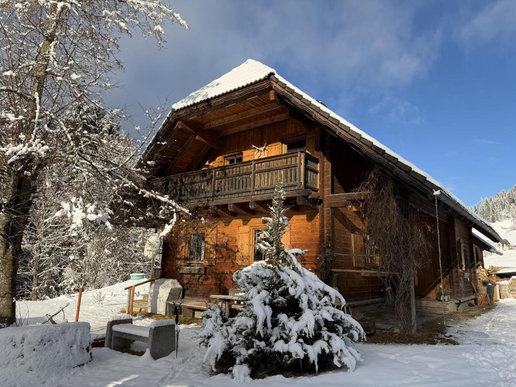 Cette cabane en rondins dispose d'un balcon dans la neige. dans l'établissement KlauBär - Hütte, à Steirisch Laßnitz