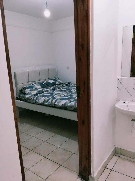 a small bedroom with a bed in a room at Kinara suites in Kiambu