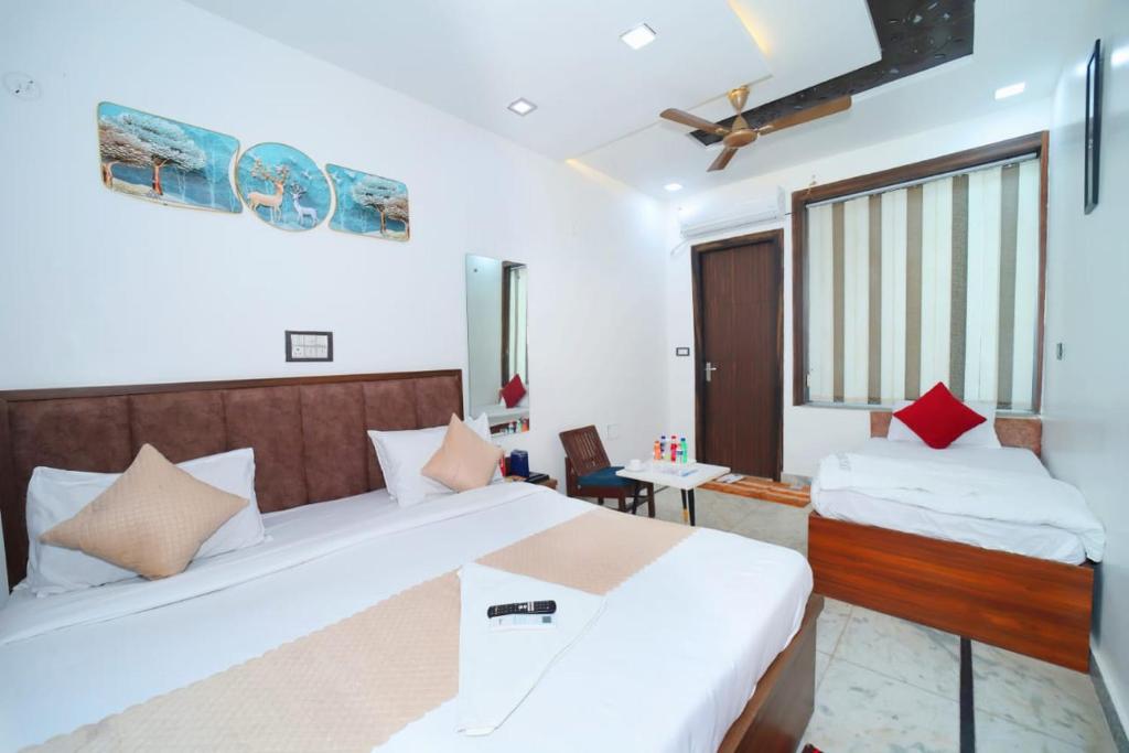 a hotel room with two beds and a desk at Taj Holiday Villa in Agra