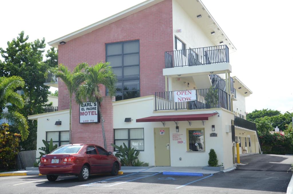 czerwony samochód zaparkowany przed budynkiem w obiekcie Carl's El Padre Motel w Miami