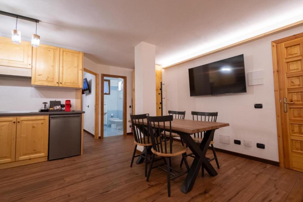a kitchen and dining room with a table and chairs at LAB Cottage in Madonna di Campiglio