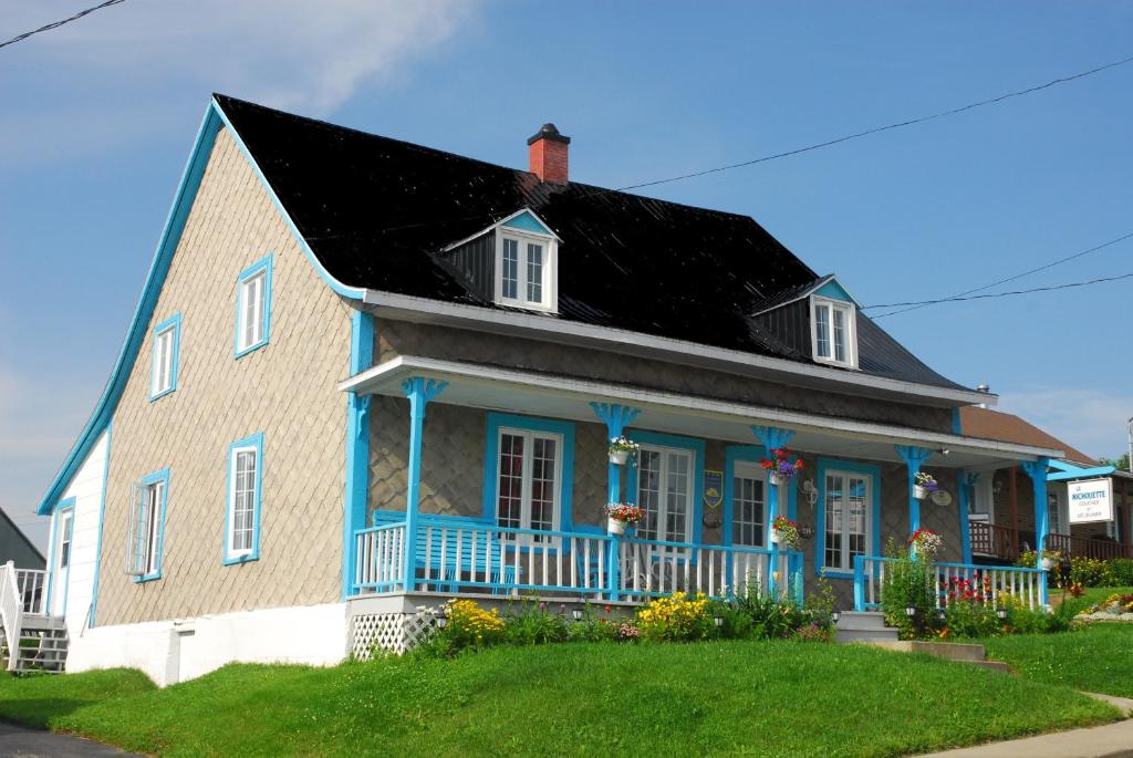 una casa azul y blanca con techo negro en Maison de campagne le Nichouette, en Les Éboulements