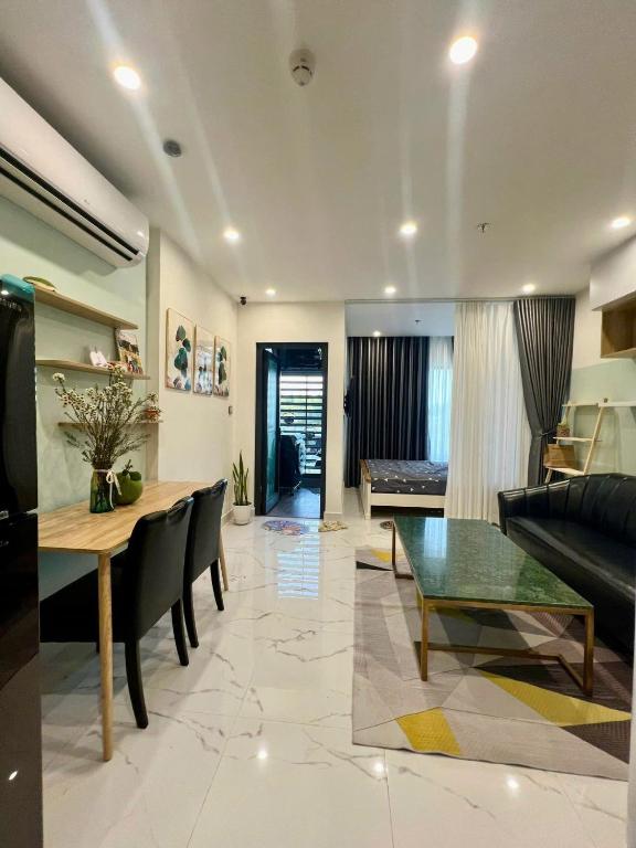 a living room with a table and a couch at Alex Vinhomes Grand in Gò Công