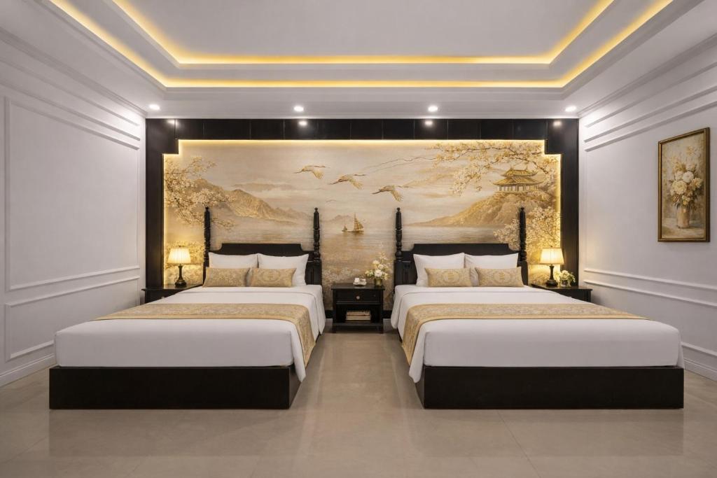 twee bedden in een kamer met een schilderij aan de muur bij The Elegant Boutique - Hue in Hue