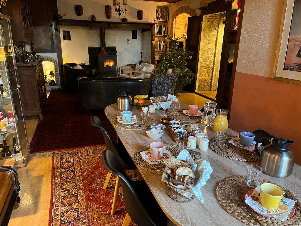 a long wooden table with plates of food on it at Chambre d'Hôtes les 3 Cochons d'Olt in Arcambal