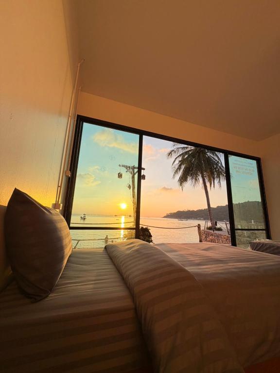 a bedroom with a bed with a view of the ocean at Malila Sea Breeze Hostel in Ko Tao