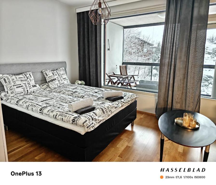 ein Schlafzimmer mit einem Bett und einem großen Fenster in der Unterkunft Cozy and modern studio in a top location in Turku