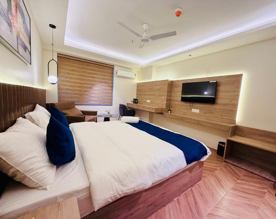 a bedroom with a large bed and a flat screen tv at StayWorks studios in Greater Noida
