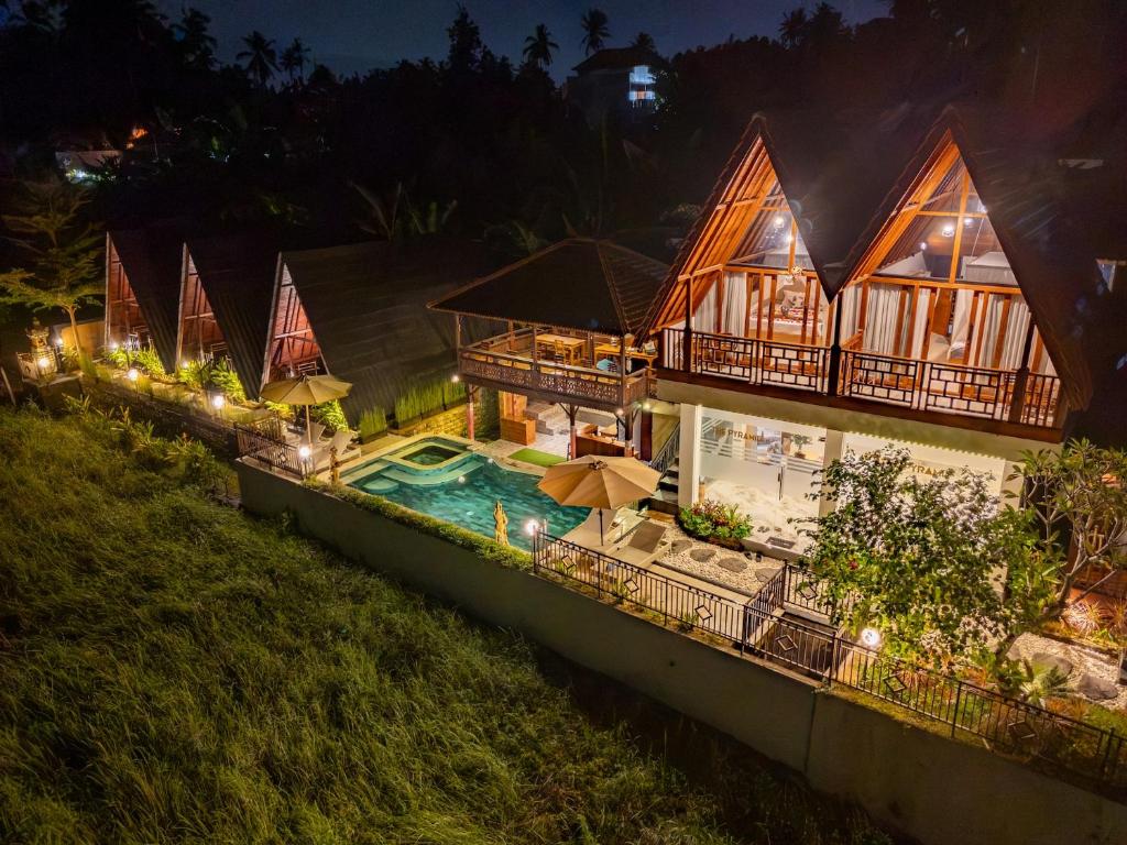 una vista aerea di una casa con piscina di notte di The Pyramid Ubud River Villas a Gianyar