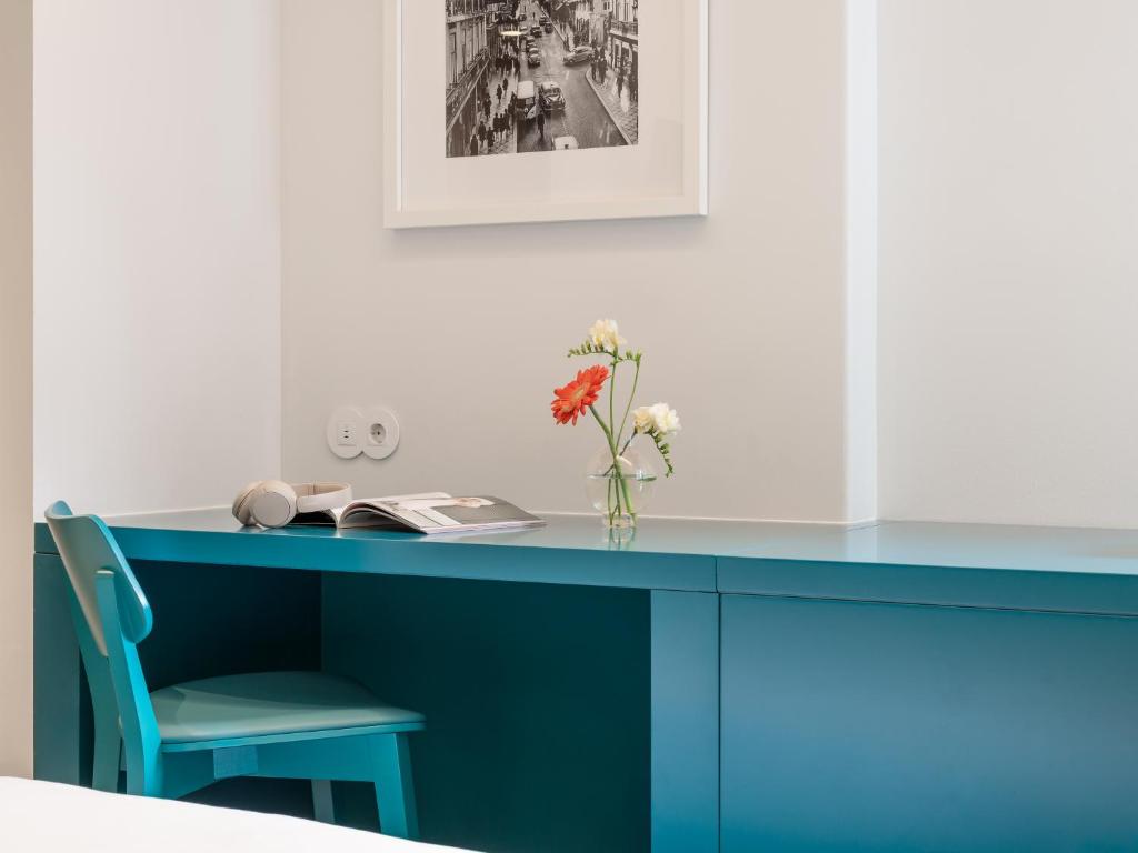 A turquoise built-in desk creates a compact work corner beside a matching chair.