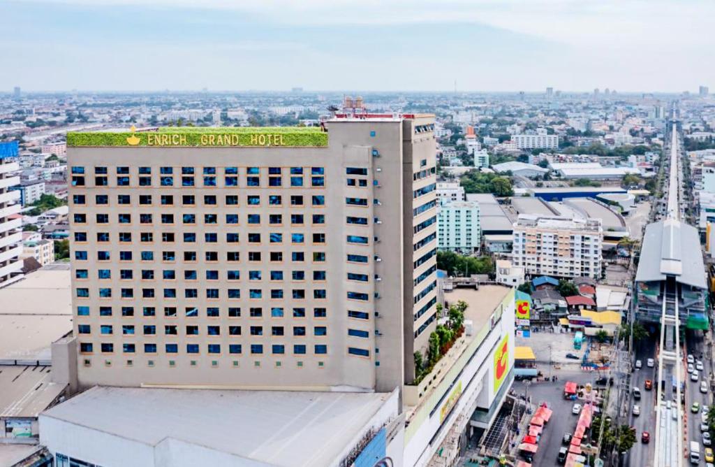een hoog gebouw met een groen dak erop bij Enrich Grand Hotel in Bangkok
