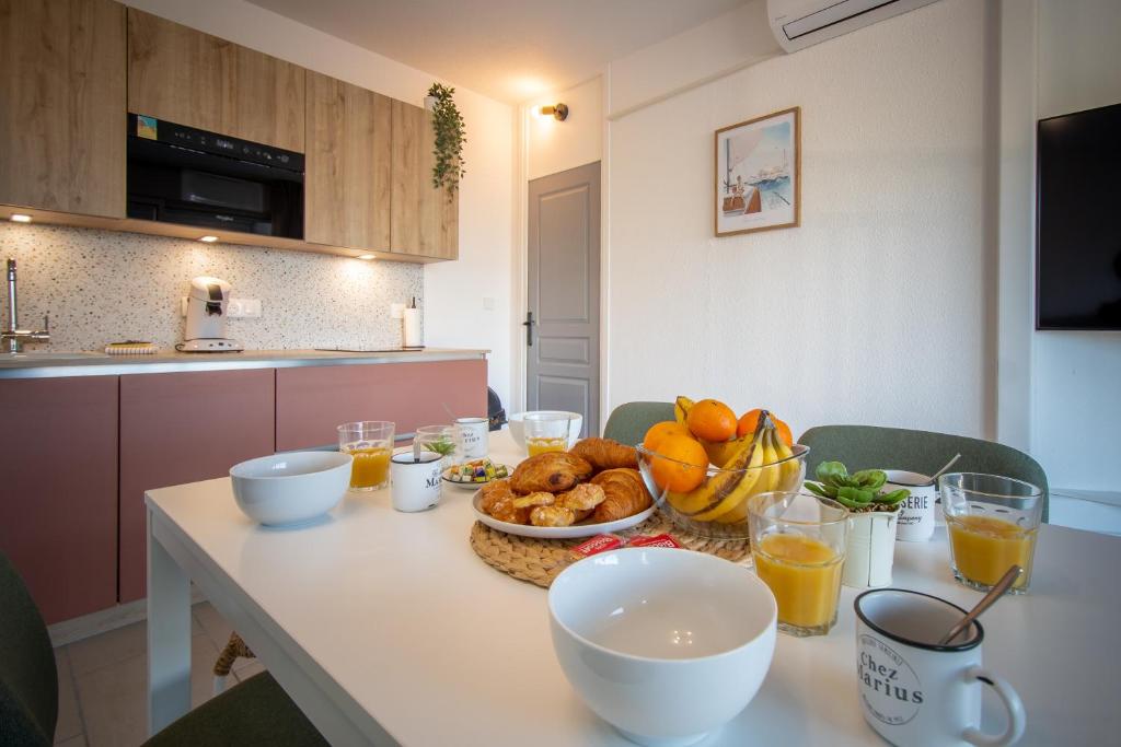 - une table avec un bol de fruits et une assiette de nourriture dans l'établissement Grand Studio front de mer - Climatiser avec place de parking, à La Celle-sous-Gouzon