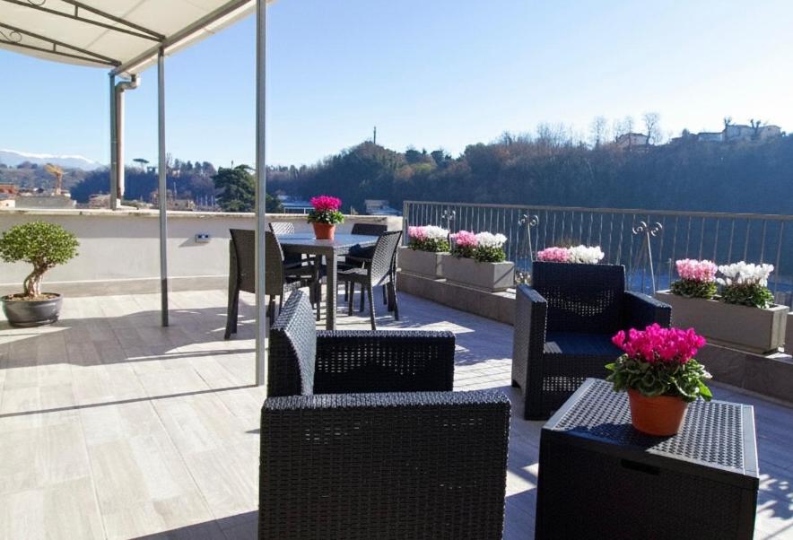 een terras met een tafel, stoelen en bloemen bij Raggio di Sole Apartment in Valmontone