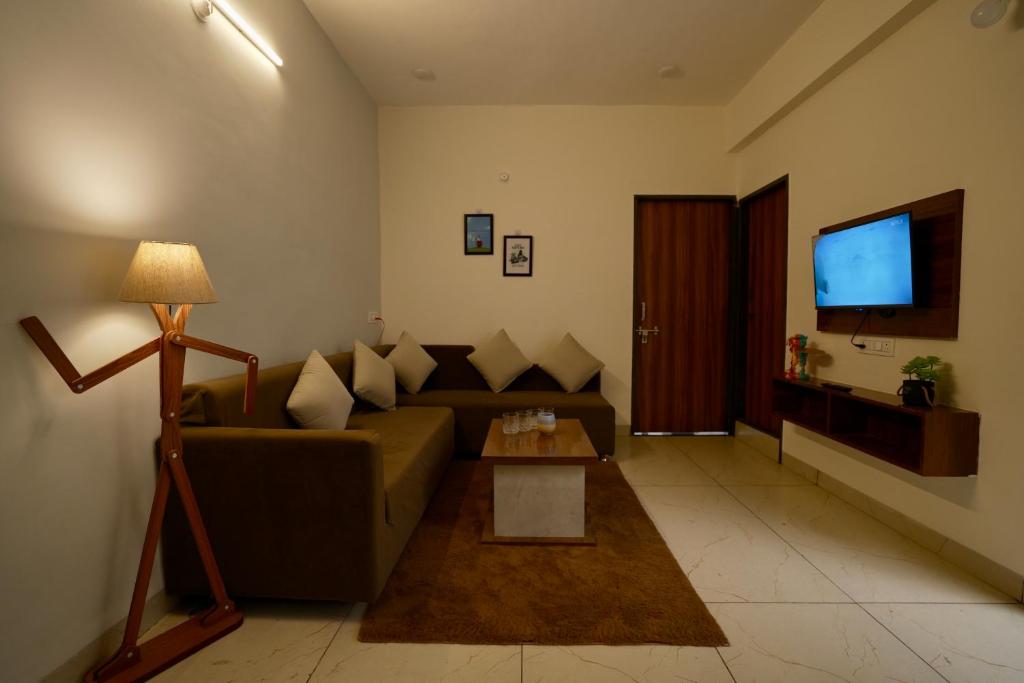 een woonkamer met een bank en een televisie bij Captain Go-Go 1 bhk apartment in Indore