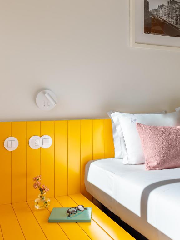 A bedside corner with a small yellow table beside the bed.