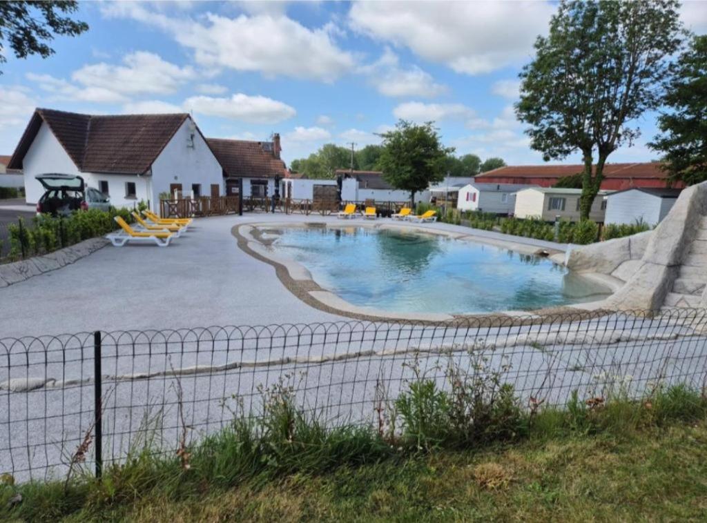 une piscine dans une cour à côté d'une maison dans l'établissement Mobil-home camping Le Ptit Rio, à Noyelles-sur-Mer