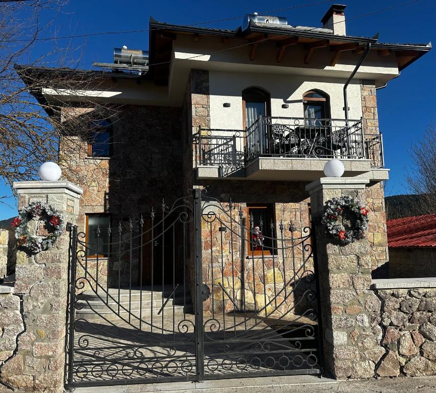 a house with a gate and a stone wall at Castle Rozafa Scutari in Voskopojë