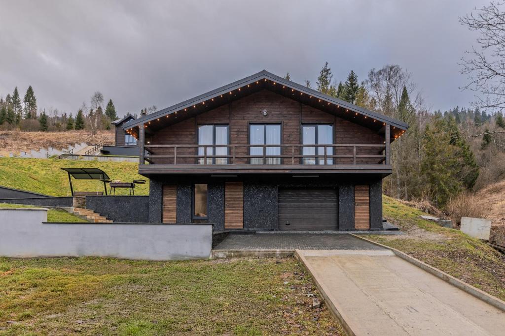 a small house with a porch on a hill at Saduba y Lukasa in Oryavchyk
