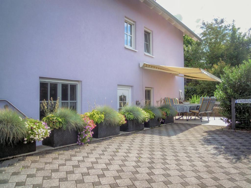 ein Haus mit Terrasse und einem Tisch mit Pflanzen in der Unterkunft Ferienwohnung Wilpert in Schwanfeld