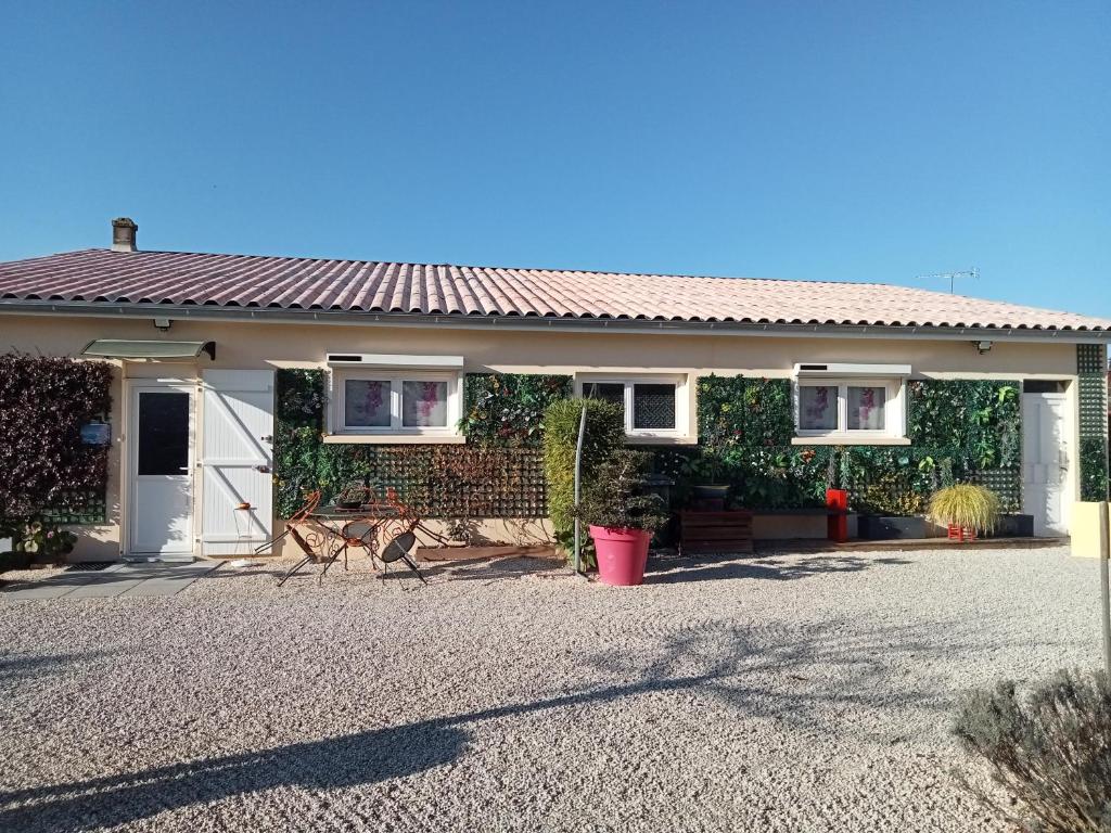 een huis met een grindoprit ervoor bij une pause quelque part au jardin des érables et des niwakis in Saint-Médard-de-Guizières
