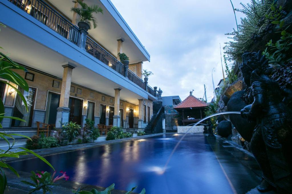 a fountain in the courtyard of a building at Wijaya Guesthouse in Canggu