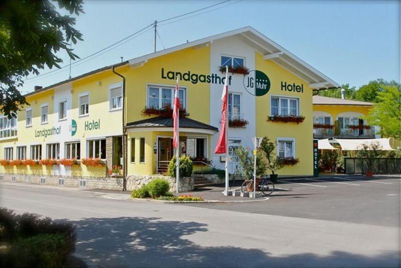 um grande edifício amarelo com um hotel numa rua em Landgasthof Hotel Muhr em Gallbrunn