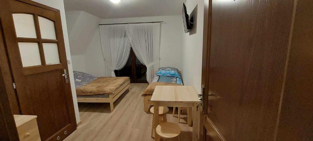 a room with a bedroom with a bed and a table at Pokoje gościnne u Sołtysów in Jurgów