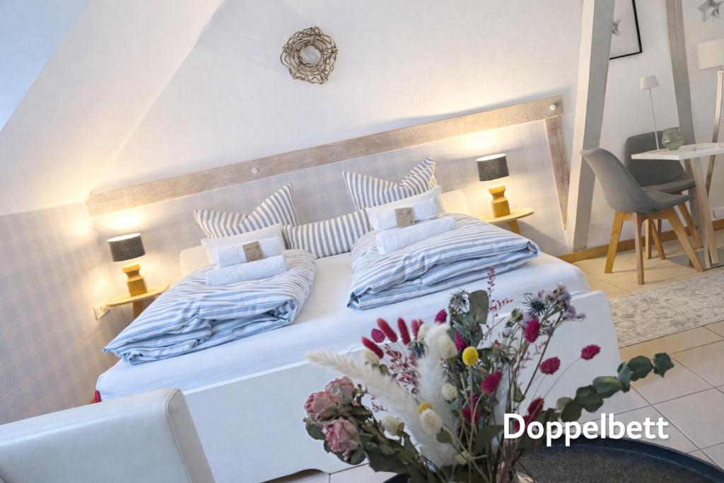 a bedroom with a large white bed with blue pillows at Weberhof - Münster 3 in Münster