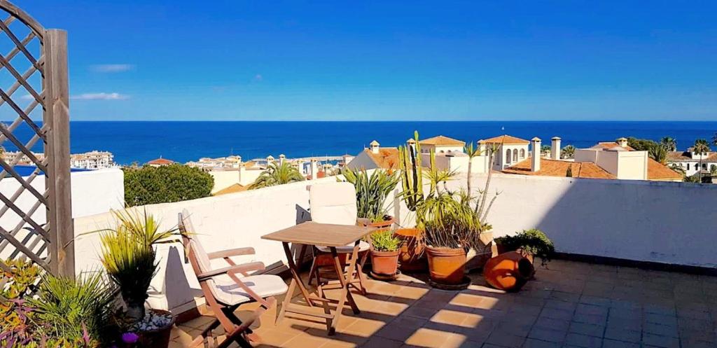 un patio con tavolo e sedie e l'oceano di La Terraza del Mar a Manilva